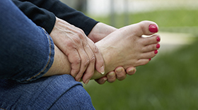 Woman holding hurting foot